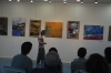 The artist Shula Rapoport explaining her picture for the Opening visitors. Back: from right to left pictures from : Aliza Borshak, Gina Meir, Shula Rapoport and Aliza Borshak.  Photographer : Guillermo Rapoport