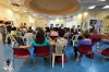The public during the Exhibitions Opening in the Municipal Library Beersheba, behind picture of artist Ruty Yotam