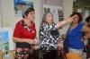 Exhibition guest Zila Hermann and Gina, behind left to right picture from Ruty Yotam and "Fruit of peace in Israel" Poster  