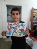 Child showing his ready paintings after "Fruits of Peace in Israel" artist Aliza Borshaks workshop in "Painting motivated by Alizas Paintings" for a class of elementary Jewish-Arabic school "Degania", Beersheba, November 2019