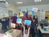 Children showing their ready paintings after Gina Meir Duellmann's workshop in "Painting hearing Waltz Melody" for a class of elementary Jewish-Arabic school "Degania", Beersheba, November 2019, with colleague artist Ana Mirons assistance