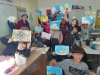 Children showing their ready paintings after Gina Meir Duellmann's workshop in "Still Life" for a class of elementary Jewish-Arabic school "Degania", Beersheba, November 2019, with colleague artist Ana Mirons assistance