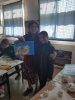 Fruits of Peace in Israel artist Gina Meir Duellmanns workshop "Still Life" for a class of elementary Jewish-Arabic school "Degania", Beersheba, December 2019, showing an example of a painting done by the girl of the class at her side