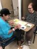 Devorah Darmo with Gina, explaining Dvorah how/what to paint a picture for the Remembering Day 7.10